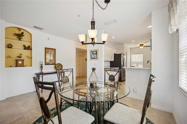 dining room with a wealth of natural light, ceiling fan with notable chandelier, and light tile floors