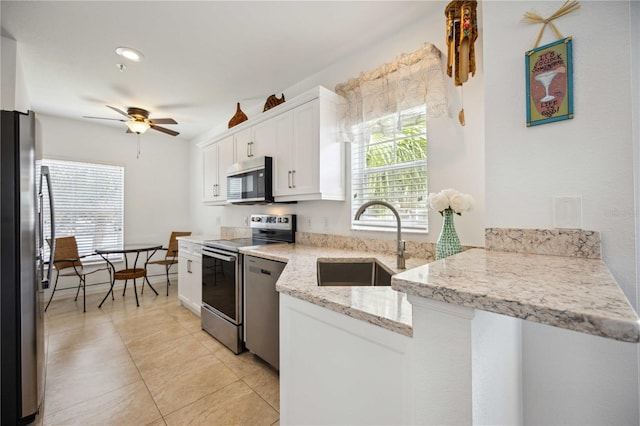 kitchen featuring white cabinetry, appliances with stainless steel finishes, sink, light stone counters, and ceiling fan