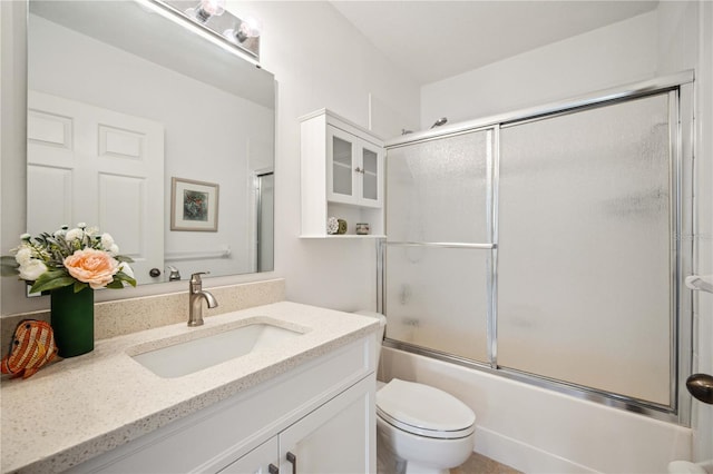 full bathroom with toilet, shower / bath combination with glass door, and vanity