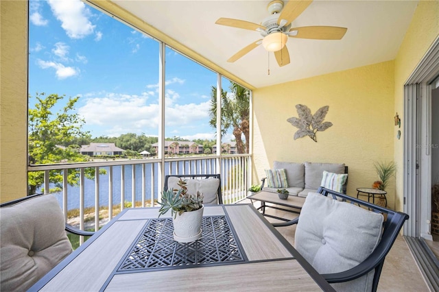 sunroom featuring a water view and ceiling fan