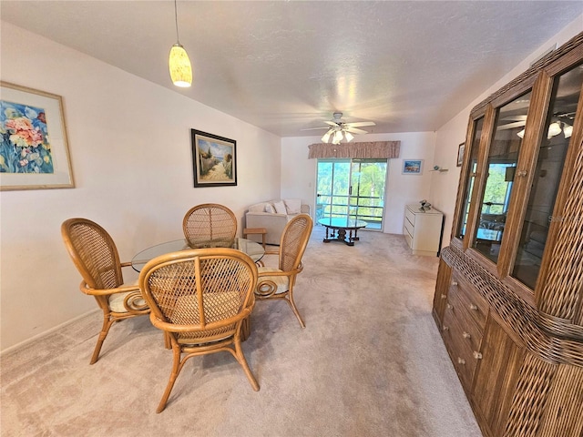 dining room featuring ceiling fan, a textured ceiling, and light carpet