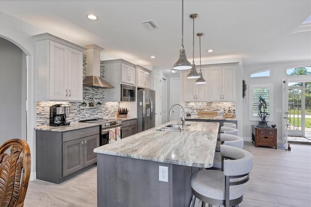 kitchen with pendant lighting, appliances with stainless steel finishes, sink, a breakfast bar area, and tasteful backsplash