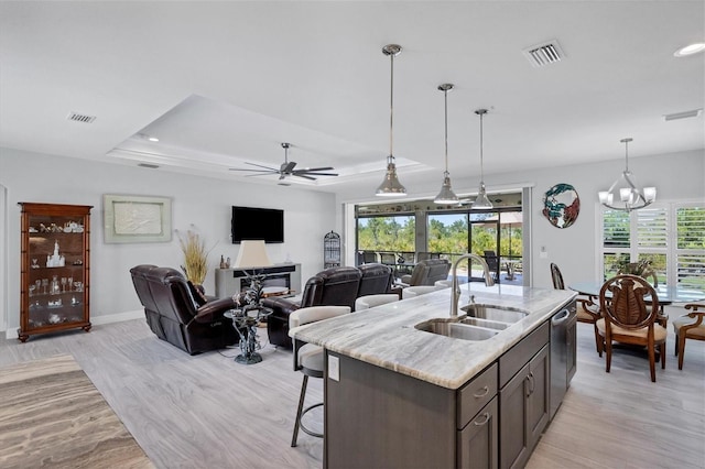 kitchen featuring a wealth of natural light, decorative light fixtures, sink, and a tray ceiling