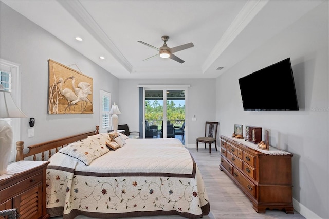 bedroom featuring light hardwood / wood-style flooring, ceiling fan, access to outside, and a raised ceiling