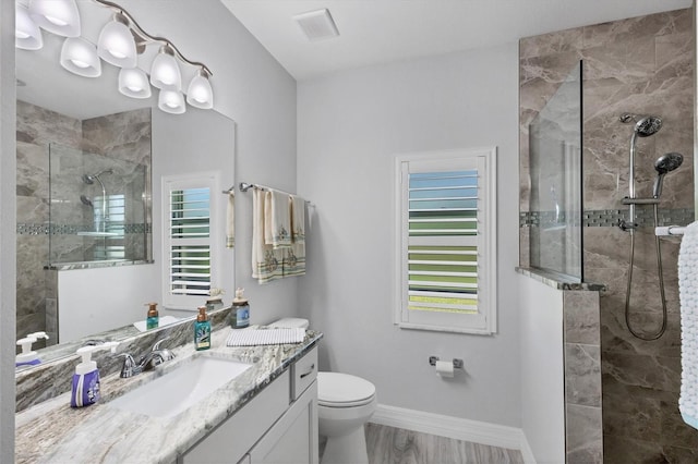 bathroom featuring an enclosed shower, hardwood / wood-style flooring, toilet, and vanity with extensive cabinet space