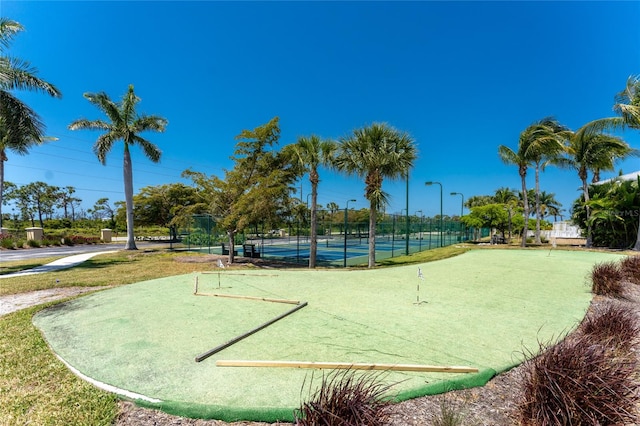 view of home's community featuring tennis court