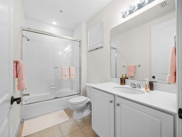 full bathroom featuring tile patterned flooring, toilet, vanity, and bath / shower combo with glass door