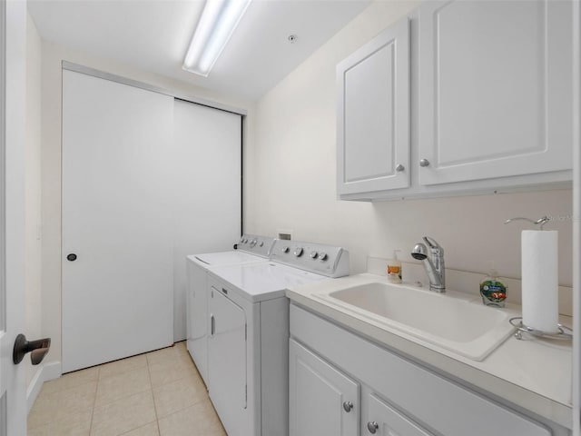 washroom with sink, light tile patterned floors, cabinets, and independent washer and dryer