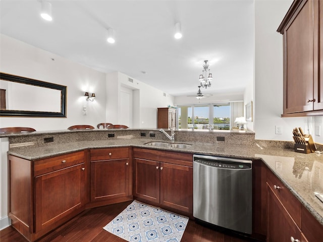 kitchen featuring stainless steel dishwasher, dark stone countertops, kitchen peninsula, and dark hardwood / wood-style floors