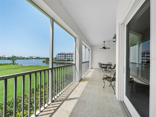 balcony featuring ceiling fan and a water view