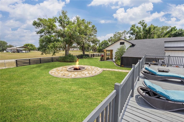 view of yard featuring a wooden deck and a fire pit