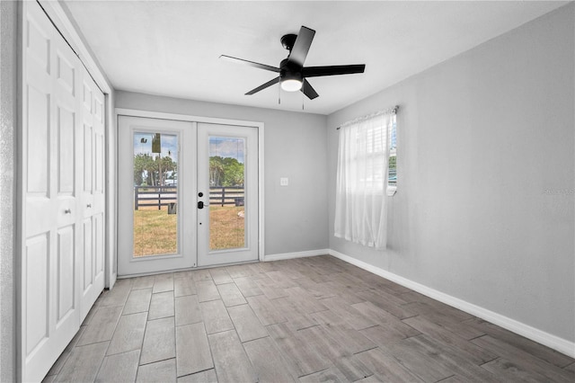 empty room featuring ceiling fan and french doors