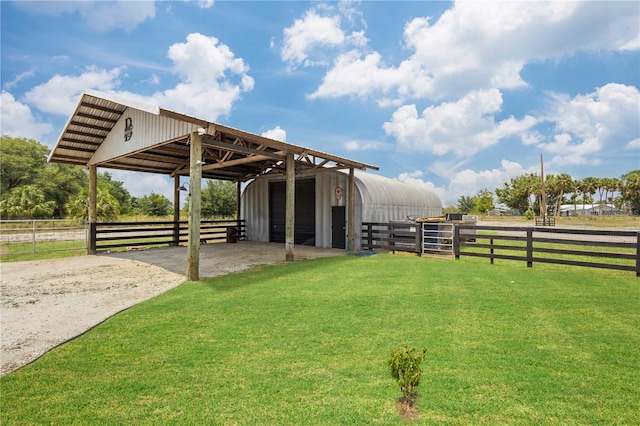 view of yard featuring an outdoor structure and a rural view