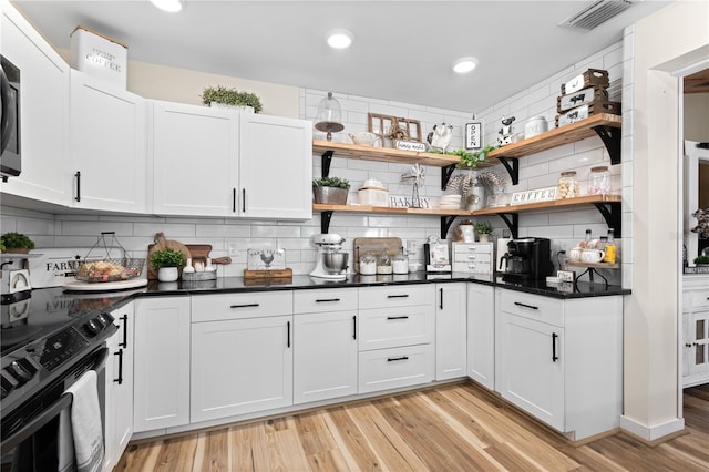 kitchen featuring backsplash, white cabinetry, range with electric cooktop, and light hardwood / wood-style floors