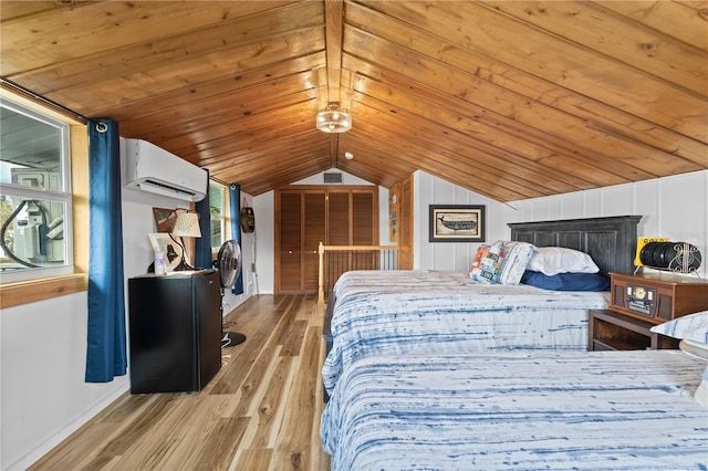 bedroom with an AC wall unit, multiple windows, vaulted ceiling, and light wood-type flooring