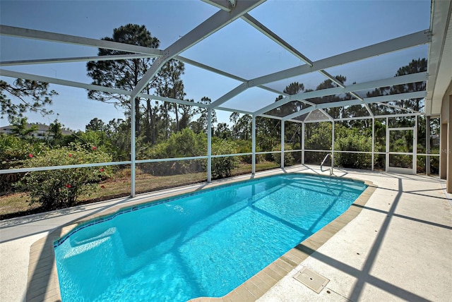 view of pool with a patio and glass enclosure