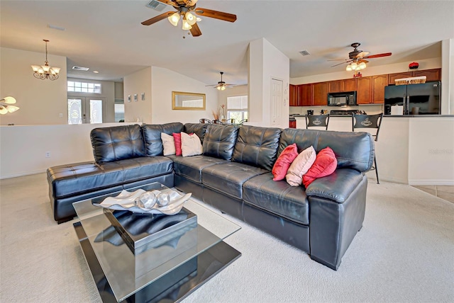 carpeted living room with ceiling fan with notable chandelier