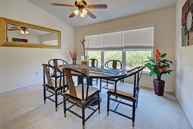 dining area with ceiling fan, vaulted ceiling, and light colored carpet