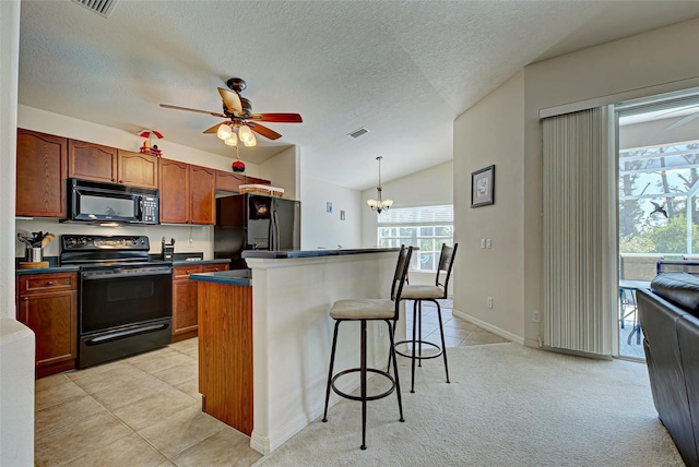 kitchen with light carpet, vaulted ceiling, black appliances, ceiling fan with notable chandelier, and a center island