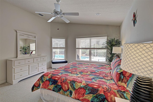 bedroom with light carpet, a textured ceiling, lofted ceiling, and ceiling fan