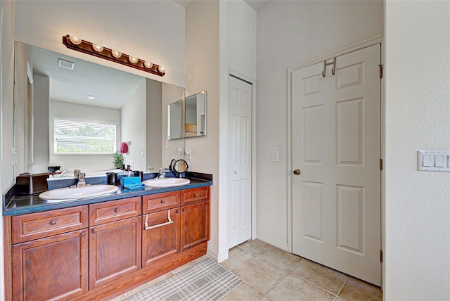 bathroom with tile flooring and dual bowl vanity