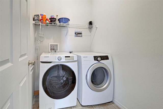 washroom with washer and clothes dryer, washer hookup, and light tile floors