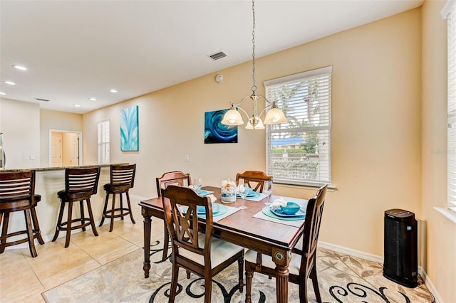 dining room with a chandelier and light tile floors