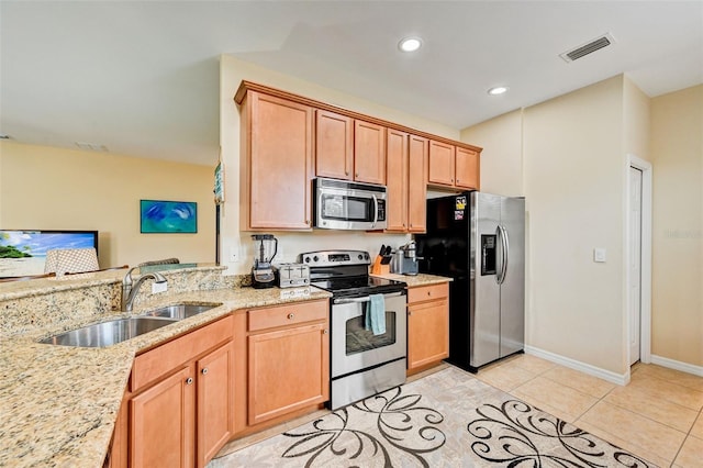 kitchen with sink, stainless steel appliances, light stone countertops, and light tile floors