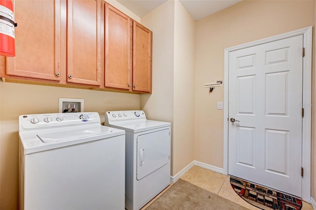 laundry area with cabinets, hookup for a washing machine, separate washer and dryer, and light tile floors