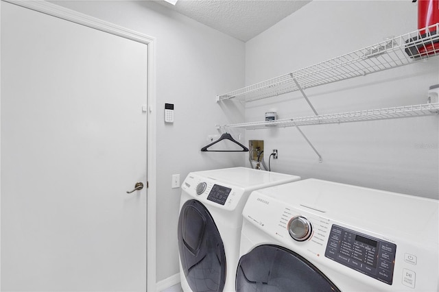 laundry area featuring washer and dryer and a textured ceiling