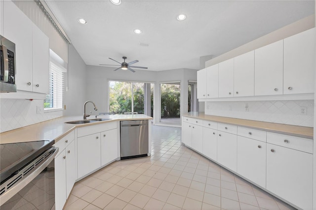 kitchen with white cabinets, sink, stainless steel appliances, and tasteful backsplash