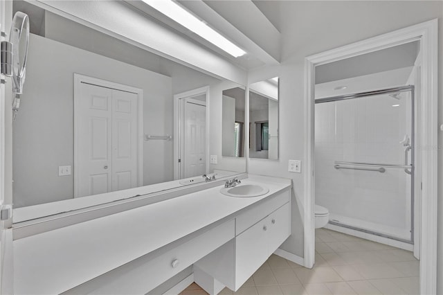 bathroom featuring tile patterned floors, vanity, toilet, and walk in shower