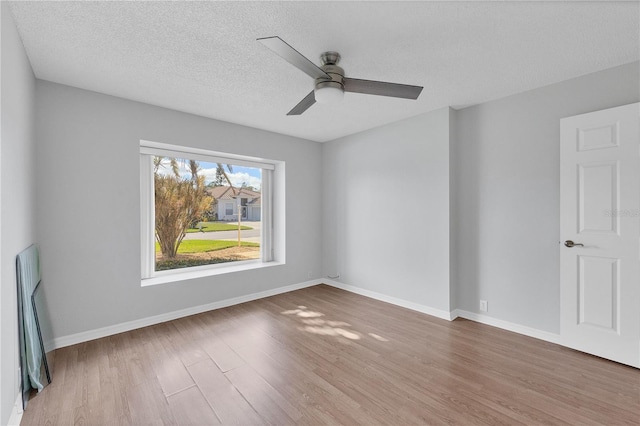 unfurnished room with hardwood / wood-style flooring, ceiling fan, and a textured ceiling