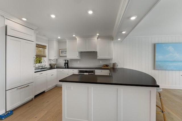 kitchen featuring white cabinetry, crown molding, light hardwood / wood-style flooring, sink, and tasteful backsplash