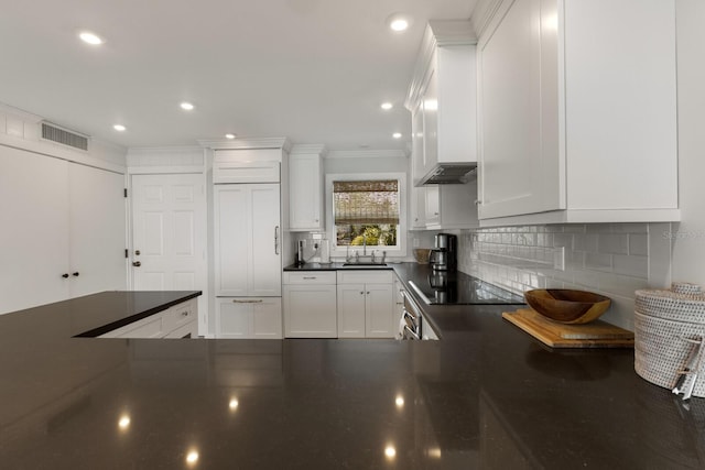 kitchen featuring backsplash, black electric cooktop, ornamental molding, white cabinets, and sink