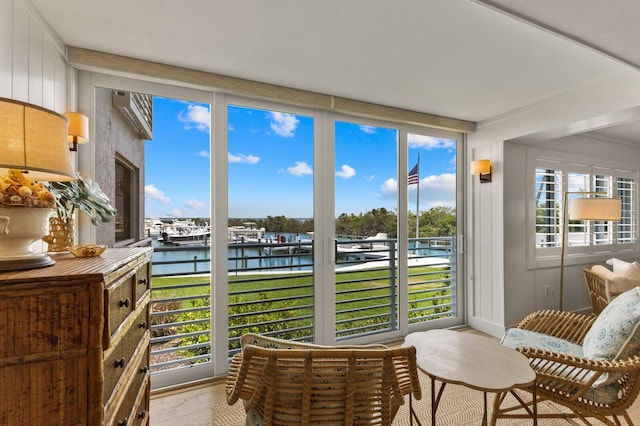 sunroom featuring a water view