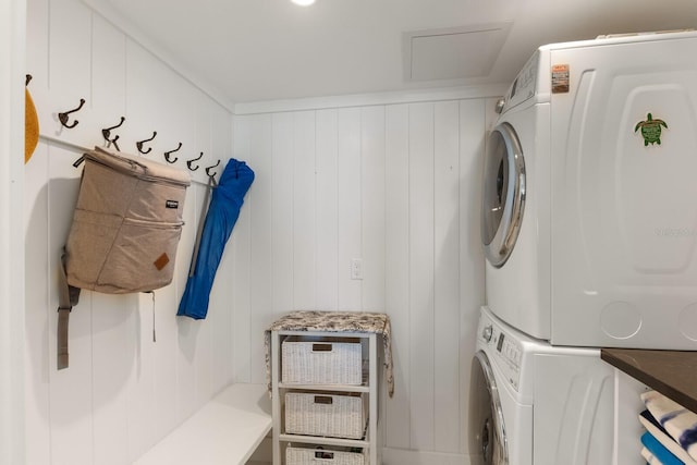 clothes washing area with stacked washing maching and dryer