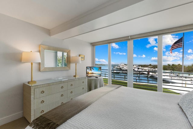 bedroom featuring carpet flooring, a water view, access to exterior, and multiple windows