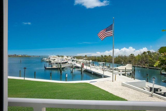 view of dock featuring a lawn and a water view