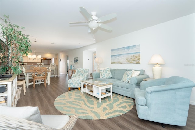 living room with ceiling fan with notable chandelier and dark wood-type flooring