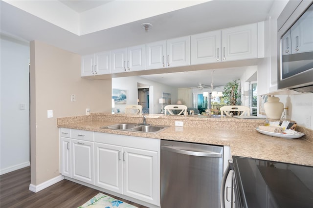 kitchen with dark wood-type flooring, range, white cabinets, sink, and stainless steel dishwasher