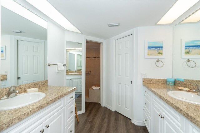 bathroom with hardwood / wood-style flooring and double vanity