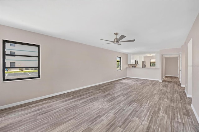 unfurnished living room featuring wood-type flooring and ceiling fan