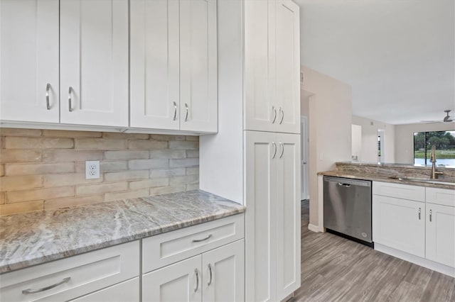 kitchen with dishwasher, white cabinets, light stone countertops, and light wood-type flooring