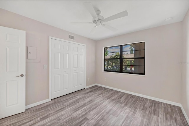 unfurnished bedroom with light hardwood / wood-style floors, a closet, and ceiling fan