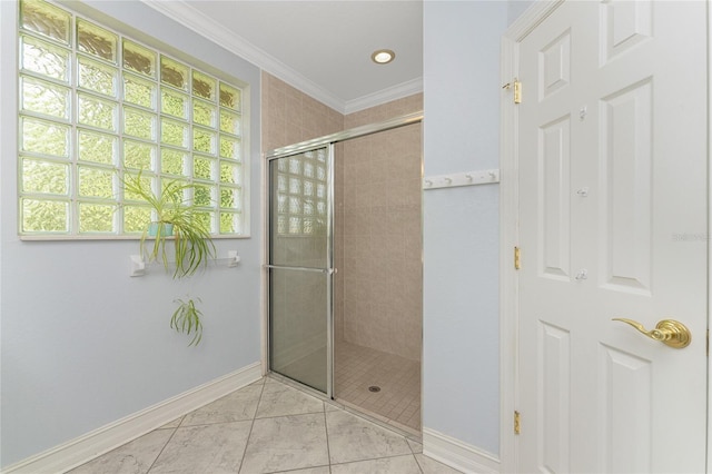 bathroom with tile patterned floors, ornamental molding, and a shower with door