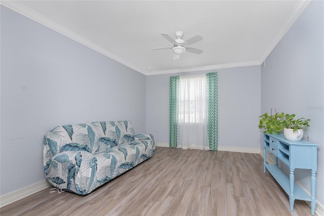 living area with ceiling fan, ornamental molding, and light wood-type flooring