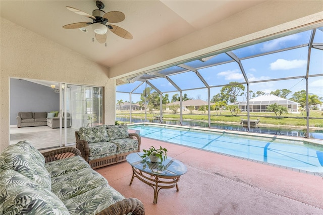 view of pool with an outdoor living space, glass enclosure, ceiling fan, and a patio area