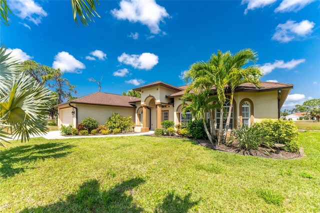 mediterranean / spanish-style house featuring a garage and a front lawn