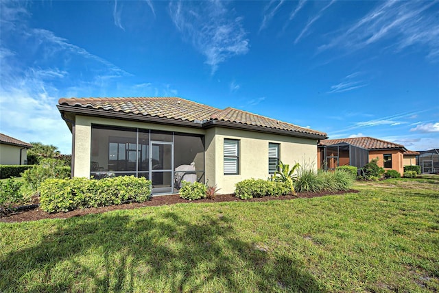 back of property with a yard and a sunroom